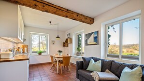 A kitchen with a dining area, a sofa, and large windows. - Apartment "Voßberg Ferienwohnung 1" with Shared Terrace & Wi-Fi (Grömitz)