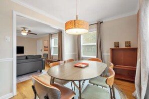Cozy dining area with a round table and six chairs, perfect for family meals and relaxation.