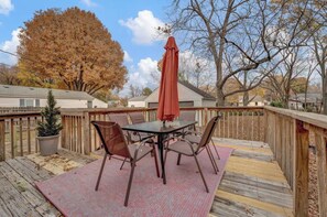Relax on the deck with a glass-top table and four chairs, shaded by an umbrella.