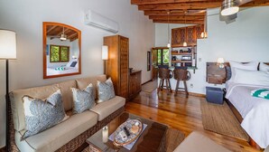 A cozy living area with a sofa, coffee table, and a dining area with chairs.