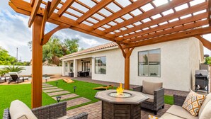 A patio with outdoor furniture, a fire pit, and a pergola. - Edgemont Escape-  3 King Beds, heated pool*, close to spring training,  (Goodyear)