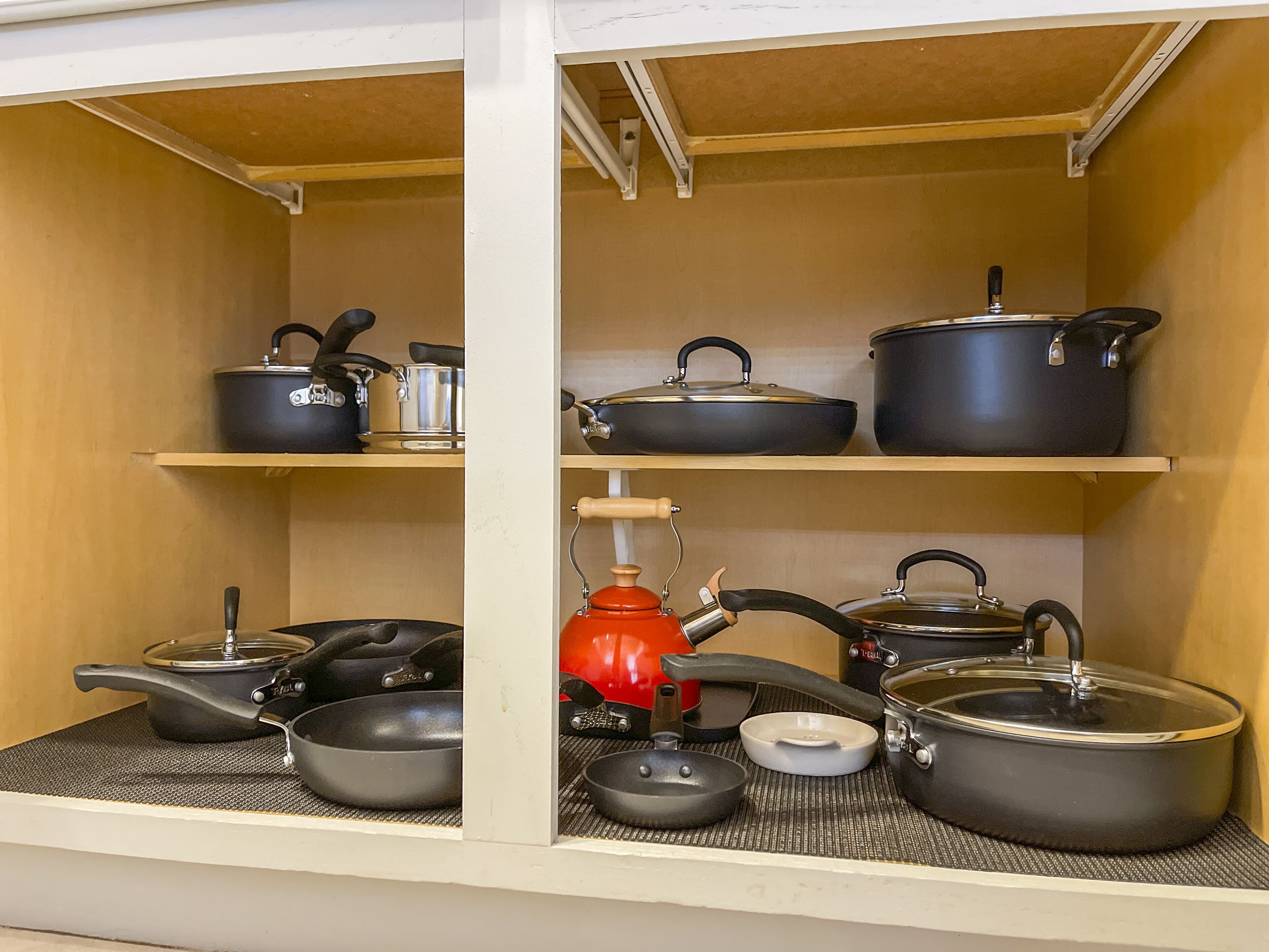A kitchen with shelves holding various pots and pans.