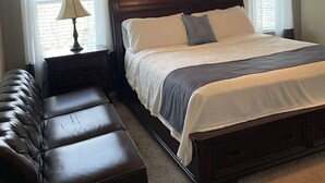 A bedroom with a bed, a bench, a nightstand, a ceiling fan, and a window with curtains. - Single home  with 5 bedrooms  sleep 10 at  a corner lot, fully garage to use (Pflugerville)