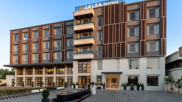 Et moderne hotel med et skakternet gulvmønster, en central gårdsplads og et skilt der siger "JALSA Retreat".