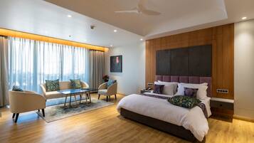 Une chambre moderne avec un grand lit, un canapé, une table basse et un fauteuil.