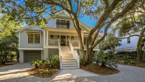 A two-story house with a front porch, a staircase leading to the entrance, and a driveway. - Live Your Best Oceanfront Life!  Exquisite Ocean Views, Private Pool, Expansive Outdoor Areas & More (Isle of Palms)