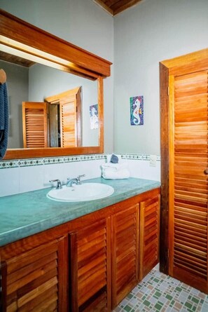 A bathroom with wooden cabinets, a sink, and a mirror.
