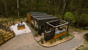 A modern cabin with a patio area, a small deck, and a fenced garden. - 5 star couples hideaway in the country, enjoy privacy and space - w hot tub (Penrose)