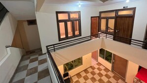 A multi-level interior with a checkered floor, a staircase, and a balcony with a railing. - Eden Rock Skardu (Skardu)