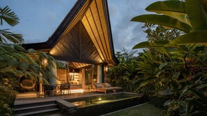 A modern house with a unique triangular roof, surrounded by lush tropical vegetation. - Desa Hay Canggu (Tumbak Bayuh)