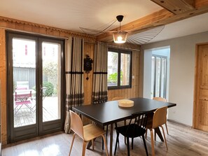 A dining area with a table, chairs, a clock, and curtains. - [CheZ BlaisE]  (Cauterets)