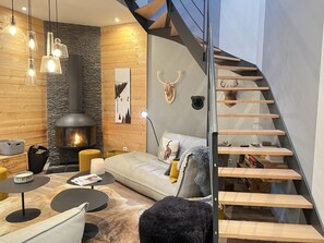 A modern living room with a fireplace, a sofa, a coffee table, and a staircase. - [CheZ BlaisE]  (Cauterets)
