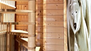 A wooden interior with a spiral staircase and a large bear sculpture.