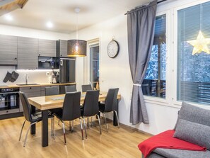 Una cocina moderna con comedor, un reloj y una ventana decorada con una estrella.