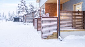 Ein modernes Gebäude mit einer Holterrasse und einer verschneiten Landschaft.