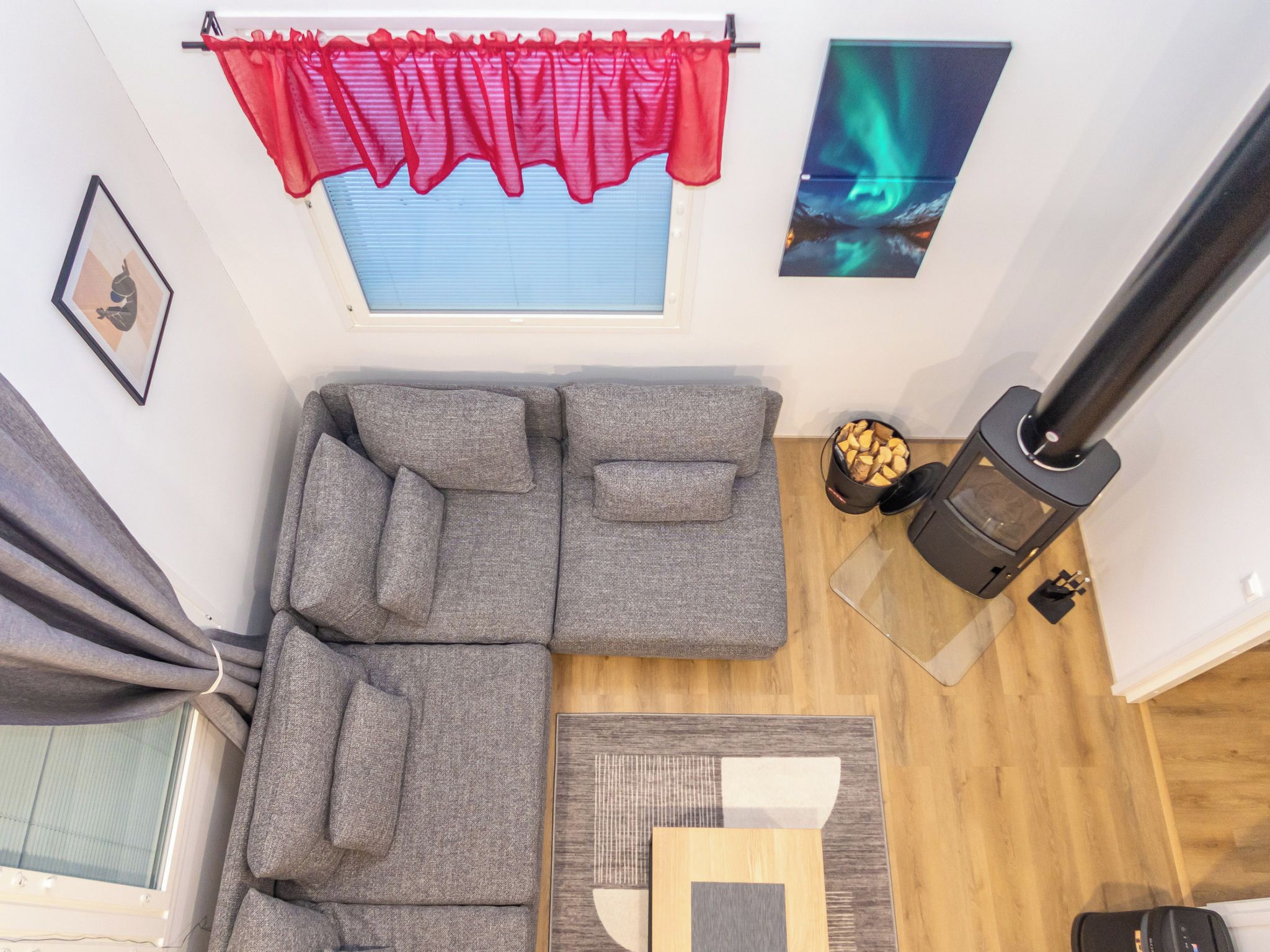 A modern living room with a sectional sofa, a fireplace, a window with blinds, and a framed picture on the wall.