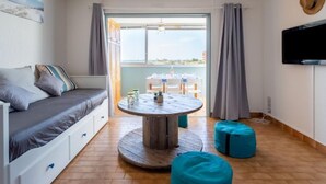 Ein gemütliches Zimmer mit einem Bett, einem runden Holztisch und einem Fernseher an der Wand.