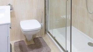 Une salle de bain moderne avec une douche à parois de verre, des toilettes et un lavabo.