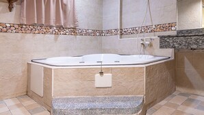 A bathroom with a freestanding bathtub, a towel rack, a shower, and a granite countertop. - Chicago Motel (Jiaoxi)