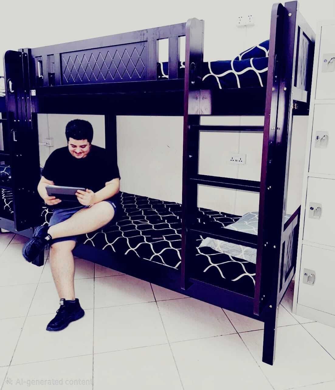 Un letto a castello con una persona seduta sul letto inferiore che legge un libro.
