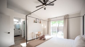 Un dormitorio moderno con una cama grande, un escritorio y vistas al exterior.