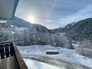A snowy mountain landscape with a clear sky and a building in the foreground. - Charming studio near center and lifts, balcony, parking (Châtel)