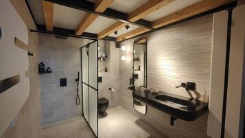 Une salle de bain moderne équipée d’une douche, de toilettes et d’un lavabo.