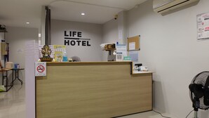 En hotellreception med en skylt som visar texten: ”LIFE HOTEL RONKHUN HOTEL”.