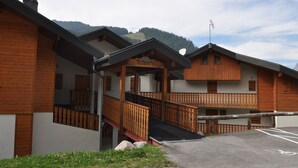Un bâtiment de style chalet en bois, doté d’un escalier menant à un balcon.