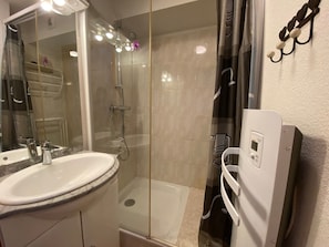 A bathroom with a glass-enclosed shower, a sink with a marble countertop, and a wall-mounted towel rack. - Cozy apartment with terrace, near village, parking included (Châtel)