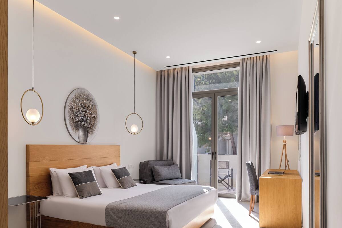 Ein modernes Schlafzimmer mit einem großen Bett, einem Schreibtisch und einem Fernseher.