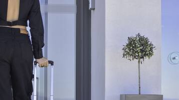 A person with a suitcase at the entrance of a building labeled "Mythical Coast Wellness Retreat."