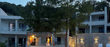 A resort with a pool, lounge chairs, and a stone wall.