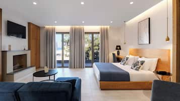 A modern hotel room with a bed, a TV, a fireplace, and a balcony with curtains.