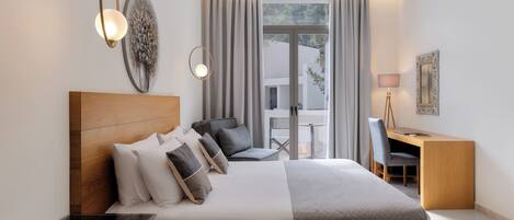 A modern bedroom with a large bed, a desk, and a chair, a small table, and a large window with curtains.