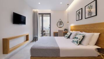 Habitación de hotel moderna con una cama grande, televisor montado en la pared y obras de arte en las paredes.