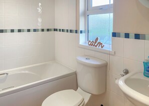 A bathroom with a bathtub, toilet, and sink.