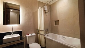 A bathroom with a sink, toilet, bathtub, and a shower with a handheld showerhead. - Grand Emilia Hotel (Cebu City)