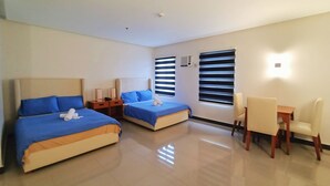 Habitación de hotel con dos camas, un escritorio y una silla.