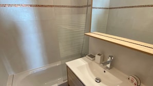 Ein Badezimmer mit Badewanne, Waschbecken und Spiegel.