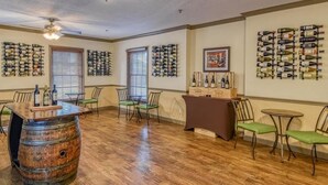 A bar area with wooden flooring, multiple wine racks on the walls, and a bar counter with stools. - Historic St. Augustine Balcony Suite with Parking (Saint Augustine)