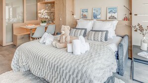 Quarto moderno com cama grande, escrivaninha e guarda-roupa.