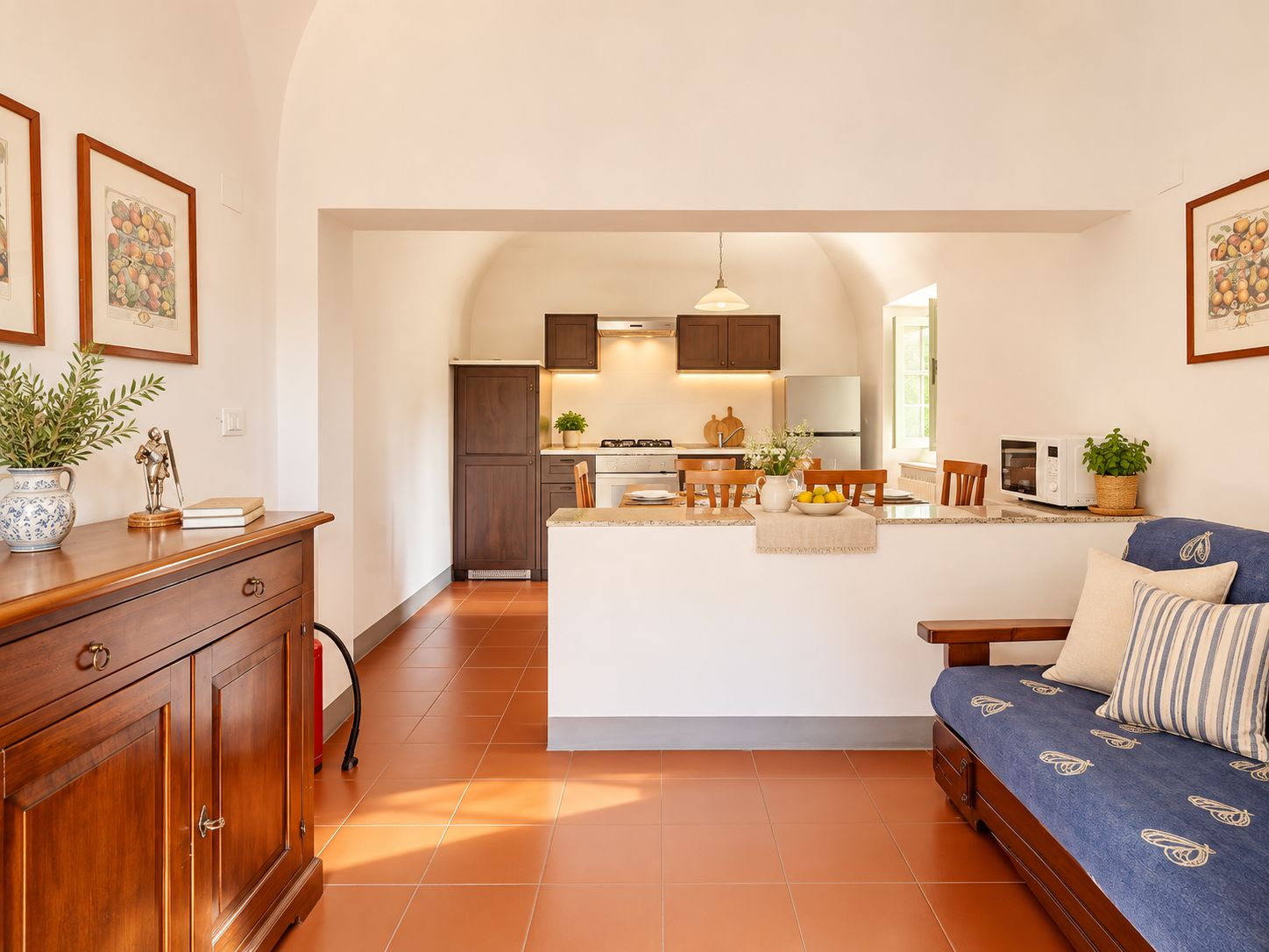 A modern kitchen with dark wood cabinets, a central island, and a dining area with wooden chairs.
