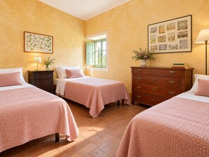 Une chambre d’hôtel avec deux lits, une commode, une fenêtre et des œuvres d’art murales.