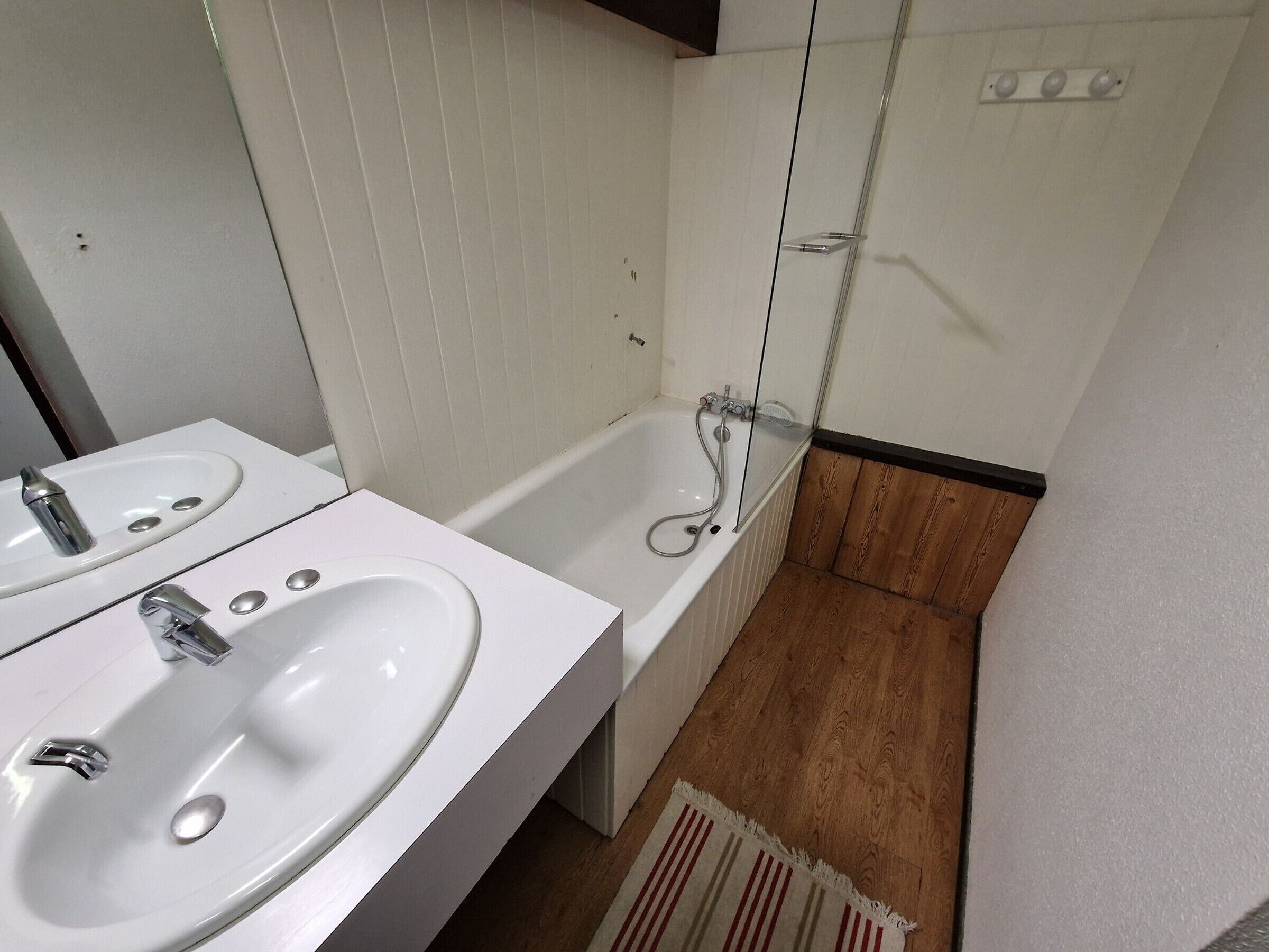 Ein Badezimmer mit zwei Waschbecken, einer Badewanne und einer Dusche.