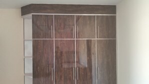 Une pièce dotée d’une grande armoire, d’un plancher en bois et d’un plafond orné de motifs géométriques.