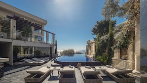 A luxurious outdoor pool area with modern lounge chairs and a clear view of the sea. - Villa Geba Boutique Hotel (Sveti Stefan)