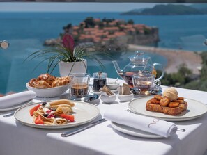 A table with breakfast items and a view of the sea. - Villa Geba Boutique Hotel (Sveti Stefan)
