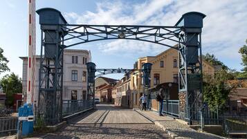 Un pont en pierre doté de garde-corps métalliques et surmonté d’une arche métallique.