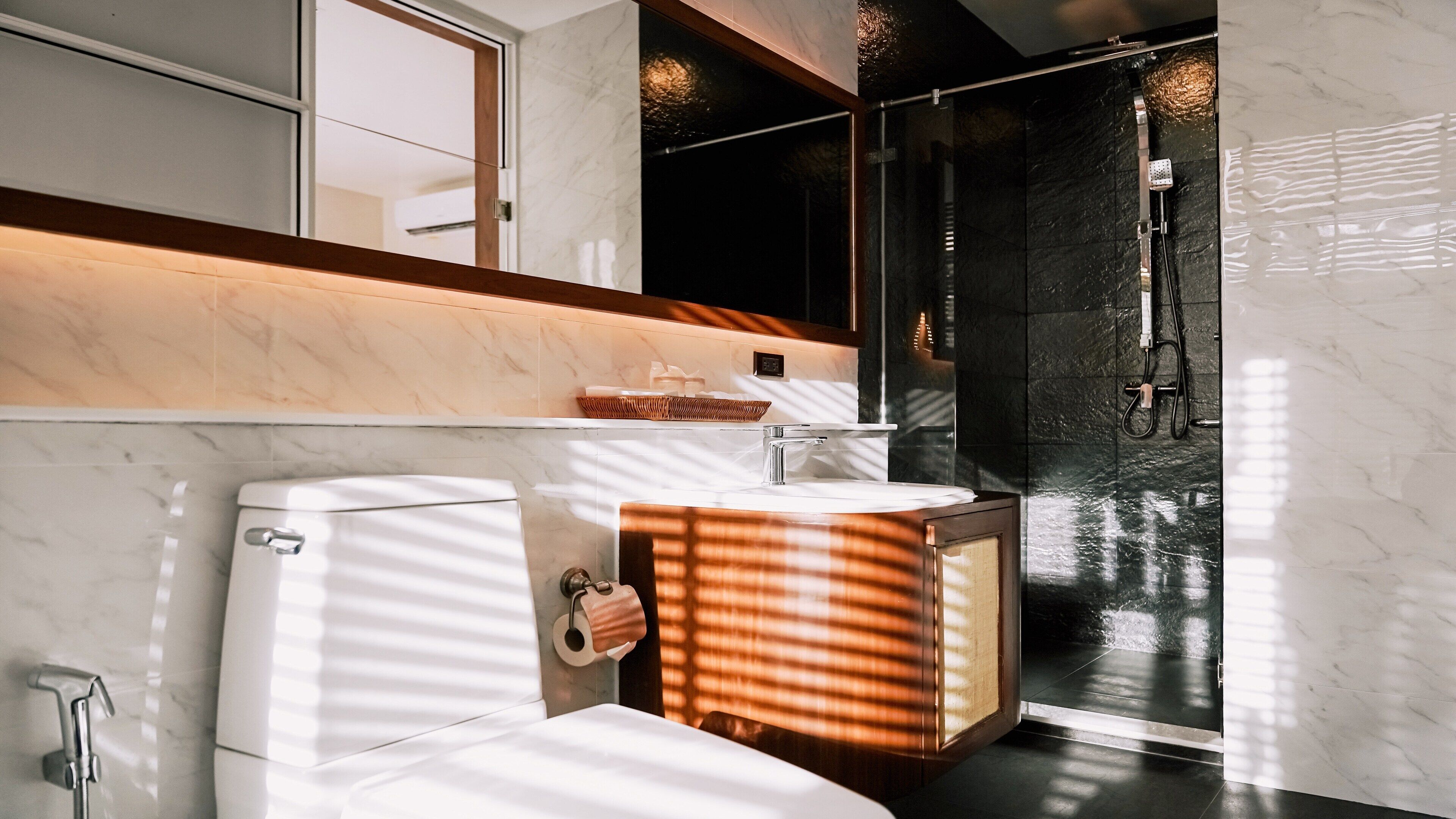 Un baño moderno con inodoro, lavamanos y ducha.